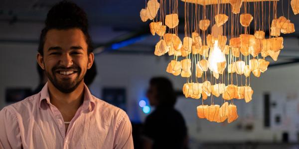 Zane Mitchell-Almoustapha with his digi-fab lamp, Sacral Chakra Chandelier