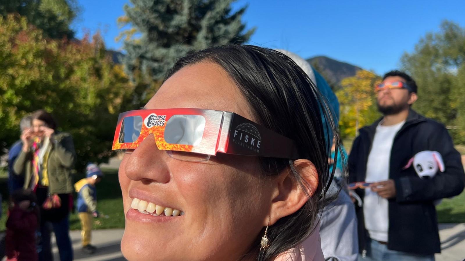 Photo of a woman with safe solar eclipses during the annular eclipse in Boulder in October 2023