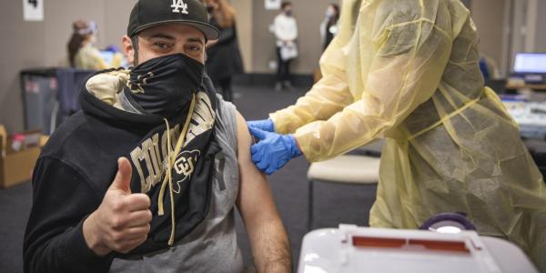 man in cu gear giving a thumbs up as he gets a shot