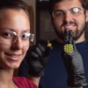 Researchers holding shape shifting material