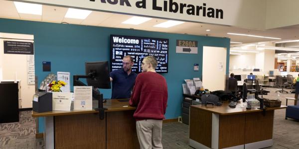 Student visits a librarian at the 'Ask a Librarian' desk