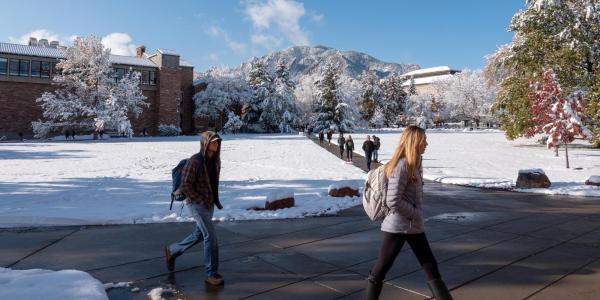 students walking across a snowy campus