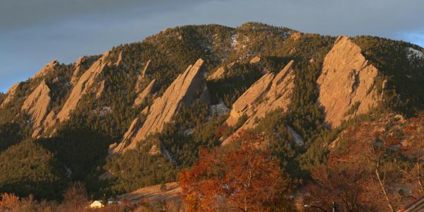 The sunrise reflects on the Boulder Flatirons.