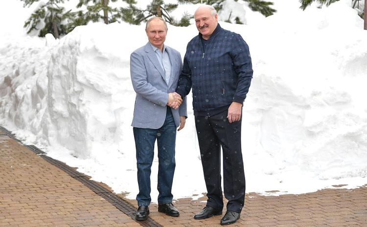 Vladimir Putin shakes hands with Alexander Lukashenko