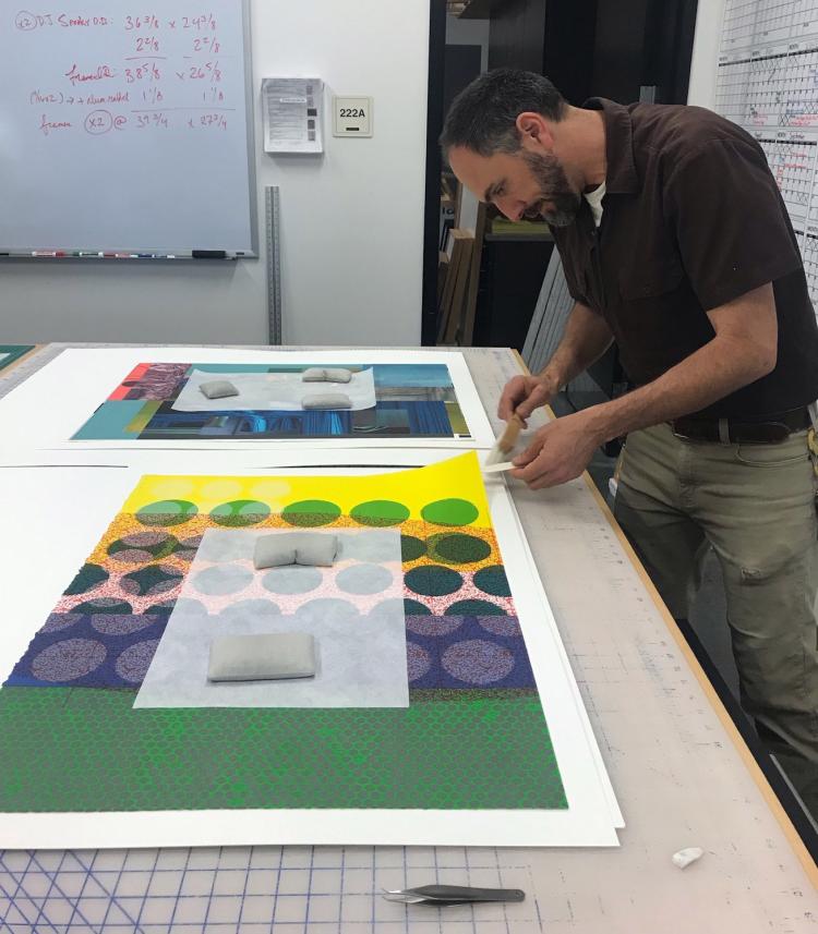 Pedro Caceres, exhibitions preparator, framing prints for the Onward and Upward exhibit at the CU Art Museum