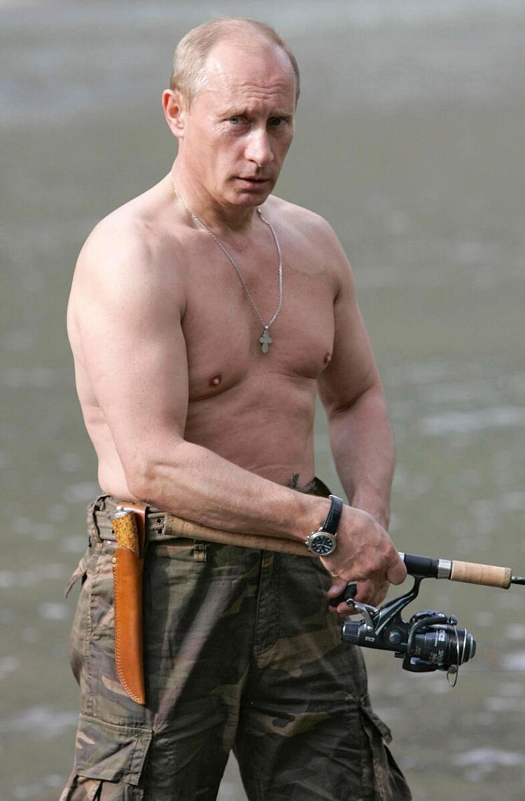 Putin stands shirtless holding a fishing rod