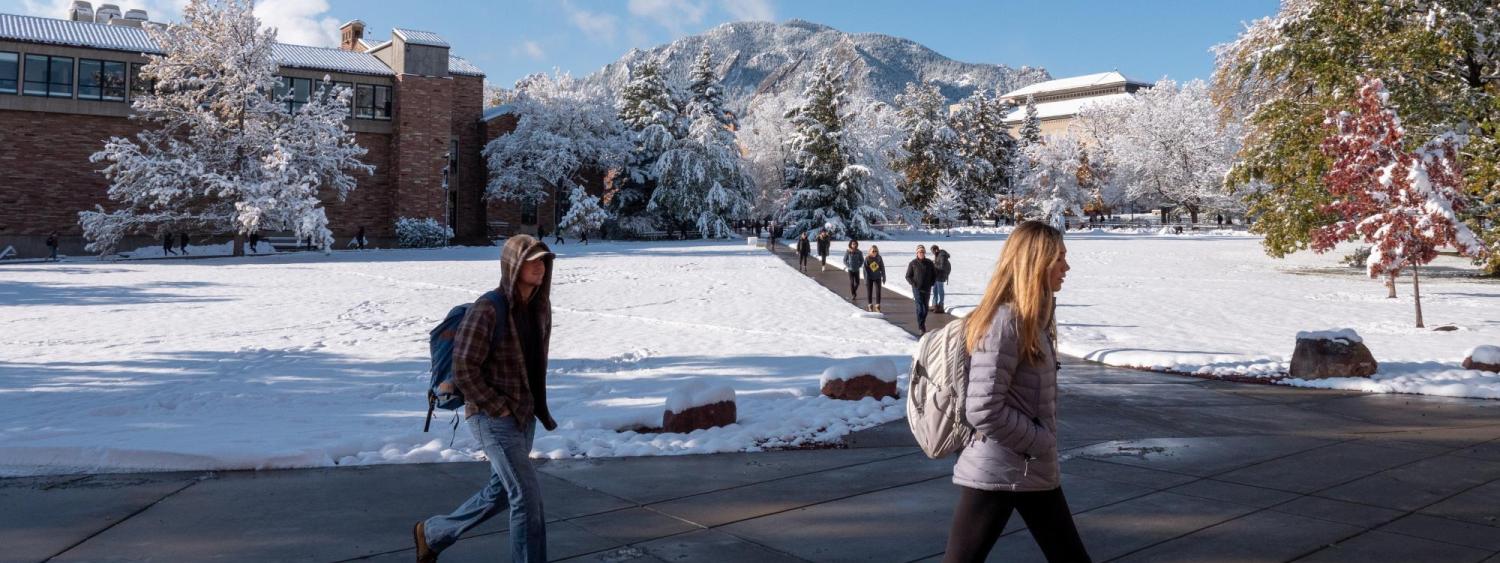 students walking across a snowy campus