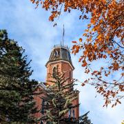 Old Main building framed by fall leaves