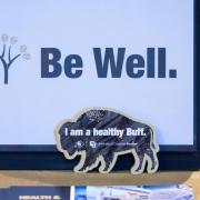 A Be Well sign on a table at a CU Boulder event.