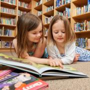 Two young children reading in a book store