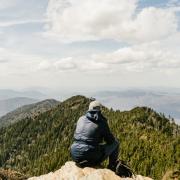 Man watches vista from mountain summit