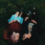 Two people lying in grass together