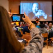 A person takes a photo of the projection at an MLK Day event on the CU Boulder campus.