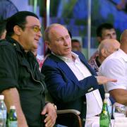 Vladimir Putin sits in a crowd at a sporting event